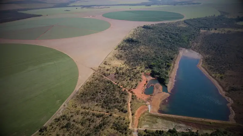 Vista aérea de propriedade rural com áreas irrigadas, reservatório de água e vegetação nativa